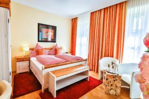 a bedroom with a bed with pink pillows at Hotel zum Goldenen Löwen in Baden-Baden