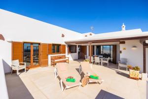 a patio with chairs and tables on a house at Villa Asomada in La Asomada