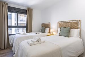 two beds in a room with a window at Nova Essential in Jávea +25 photos