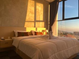 um quarto com uma cama grande e uma janela grande em Loren Hotel Kopeng em Kopeng