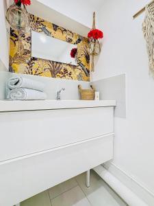 a bathroom with a white sink and a mirror at Suite Lou - Chic & Confort in Bray-Dunes