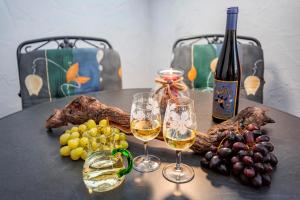 a table with two glasses of wine and grapes at Ferienhaus Sternschnuppe in Oberwesel +7 photos