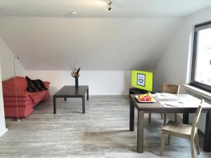 a living room with a red couch and a table at Ferienwohnung Kreuder in Bergisch Gladbach