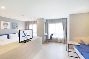 佛统Xen Hotel Nakhon Pathom - SHA PLUS的酒店客房设有一张床和一台电视。 更多37张照片