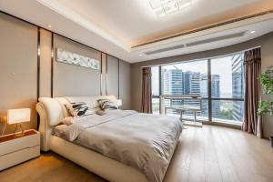 苏州苏州预见服务公寓的一间带大床和大窗户的卧室
