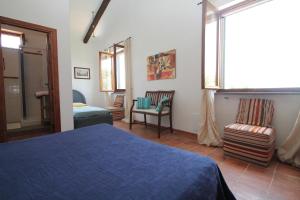sypialnia z łóżkiem, krzesłem i oknem w obiekcie Villa Tresino B&B w mieście Santa Maria di Castellabate