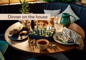 a wooden table with a chess board and dishes of food at Home Hotel Amanda in Haugesund