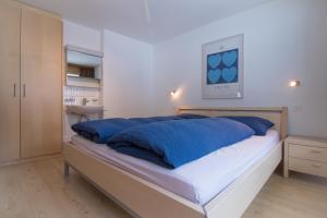 a bedroom with a large bed with blue pillows at Mischi 5 in Saas-Fee