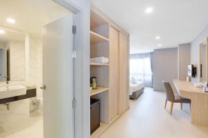 佛统Xen Hotel Nakhon Pathom - SHA PLUS的一间带水槽、书桌和桌子的浴室