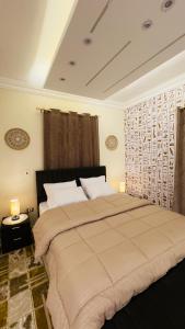 a bedroom with a large bed and two lamps at Horus pyramids view in Cairo