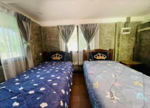 a bedroom with two beds and a window at Rublom Resort Mae Taeng in Ban Pak Thang