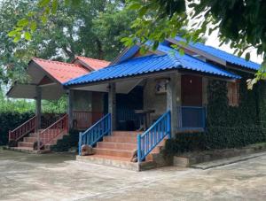 a small house with a blue roof and stairs at Rublom Resort Mae Taeng in Ban Pak Thang