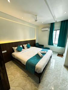 a bedroom with a large bed with blue pillows at Hotel Emerald in Visakhapatnam +20 photos