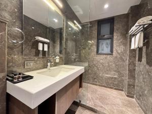 ein Badezimmer mit Waschbecken und Dusche in der Unterkunft The Eastern Grace Hotel in Buxar + 44 Fotos