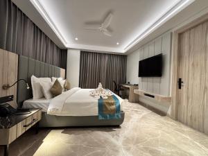 ein Schlafzimmer mit Bett und Flachbildfernseher in der Unterkunft The Eastern Grace Hotel in Buxar