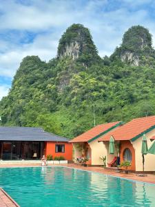a resort with a swimming pool in front of a mountain at Phong Nha Eco Village in Phong Nha