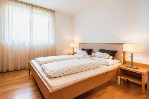 a bedroom with a large bed and a window at Unterpenatz Schenna in Schenna +9 photos