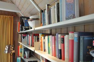 a book shelf filled with lots of books at Haus an der Koppel in Lübeck