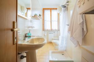 a white bathroom with a sink and a toilet at a pochi passi dal centro in Bolgheri +42 photos