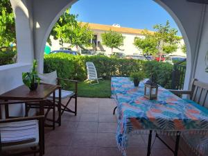 an outdoor patio with two tables and chairs and cars at Costa Arenal 81 in Arenal d'en Castell