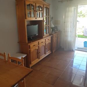 a living room with a tv and a wooden entertainment center at Costa Arenal 81 in Arenal d'en Castell