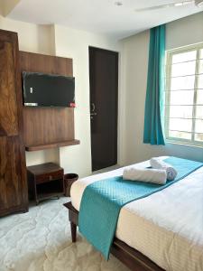 a bedroom with a bed and a flat screen tv at Hotel Emerald in Visakhapatnam