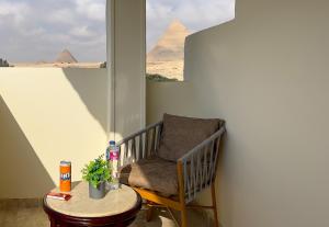 a chair and a table in a room with pyramids at Giza Pyramids Inn in Cairo