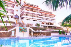 a hotel with a swimming pool in front of a building at Coral Los Alisios in Los Cristianos