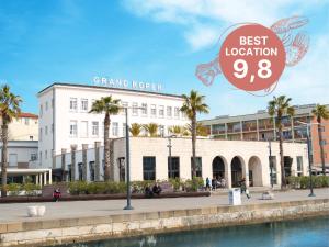 un gran edificio blanco con un cartel que dice mejor ubicación en Hotel Grand Koper, en Koper
