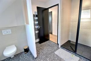 a bathroom with a toilet and a glass door at Ty antely in Trédarzec +32 photos