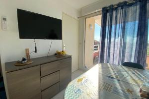 Schlafzimmer mit einer Kommode und einem Flachbild-TV in der Unterkunft comfort and breathtaking view in Frontignan