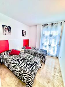 2 Betten in einem Zimmer mit Zebramuster in der Unterkunft Ventura Park B 4 in Salou