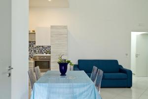 a dining room with a blue table and a blue couch at La terrazza dei tramonti in Capaccio-Paestum
