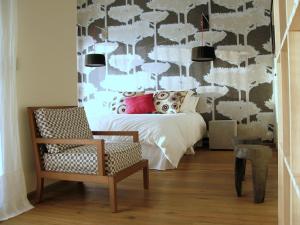 a bedroom with a bed and a chair at Le Clos Du Lac - location de chambres in Veyrier-du-Lac