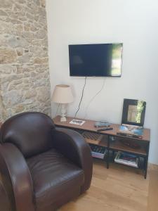 ゲランドにあるMaison de charme avec Jardin-Calme- Fibreのリビングルーム(革張りの椅子、テーブル付)