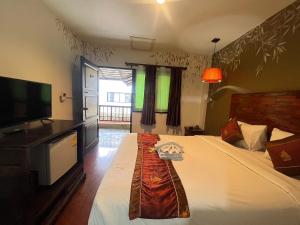 a bedroom with a bed and a flat screen tv at Thapae Boutique House in Chiang Mai