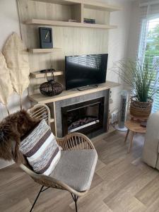 a living room with a chair and a fireplace at Chalet Oase VB01 Renesse in Renesse