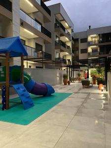 a playground in front of a apartment building at Apto em Home Clube na Praia de Palmas in Governador Celso Ramos