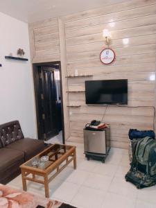 a living room with a couch and a tv at Al Raheem Guest House in Hyderabad