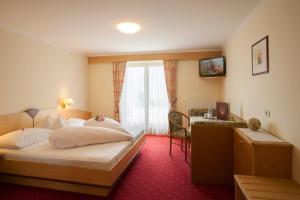 Postel nebo postele na pokoji v ubytování Hotel Garni Alpes