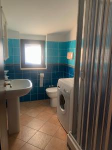 a bathroom with a toilet and a washing machine at Casa vacanze Apollonia in Marina di Camerota