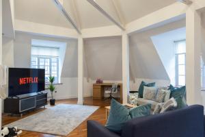 a living room with a tv and a couch at City Centre Penthouse Apartment in Leeds