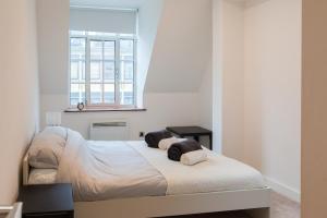 a bedroom with a bed and a window at City Centre Penthouse Apartment in Leeds +39 photos