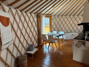 a room with a table and chairs in a yurt at Yurt in Be Bernartice in Bernartice