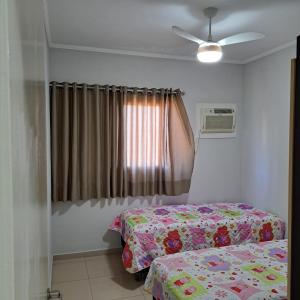 a bedroom with a bed and a ceiling fan at Apartamento Villagio Olímpia in Olímpia +14 photos