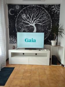 a tv on a white table in a living room at L'instant bien-être in Le Luc +3 photos