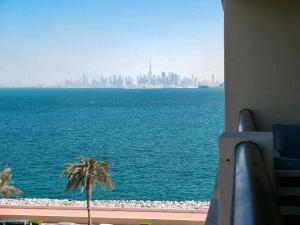 a view of the ocean and a city from a building at Ambient 1BR Apartment On The Beach at 5 Star Resort in Dubai