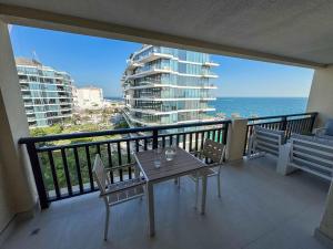 a balcony with a table and chairs and the ocean at Ambient 1BR Apartment On The Beach at 5 Star Resort in Dubai