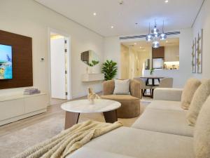 a living room with a couch and a table at Ambient 1BR Apartment On The Beach at 5 Star Resort in Dubai