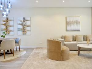 a living room with a couch and a table at Ambient 1BR Apartment On The Beach at 5 Star Resort in Dubai